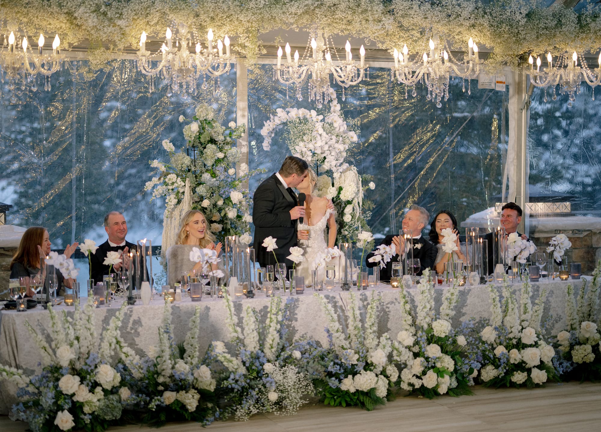 A candlelit winter reception beneath crystal chandeliers, planned by Planned by Peter