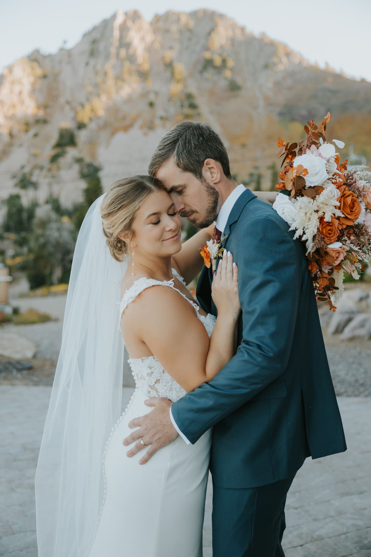 A couple embracing against Utah red rock at golden hour
