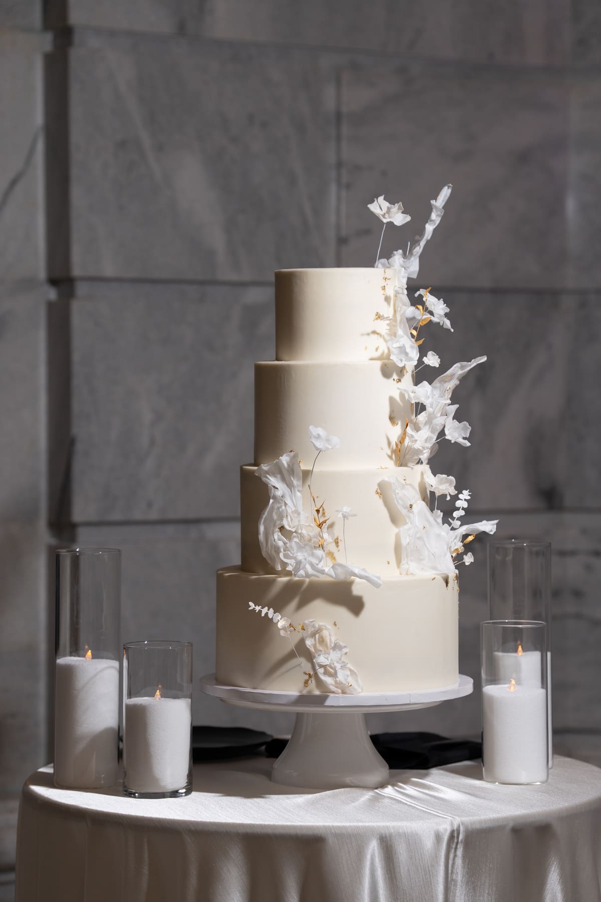 A tiered white wedding cake with sculptural sugar florals